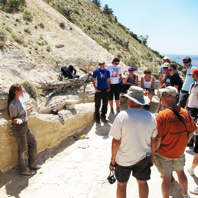 intern giving an outdoor talk to group of visitors