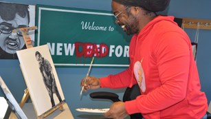 Volunteer painting on a canvas