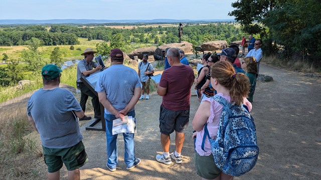 A Group of people listen to a ranger on Little Round Top