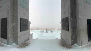 The view from inside the Pennsylvania Memorial looking out a a snow covered battlefield.