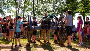 A park volunteer instructs children on the roles of Civil War artillery soldiers.