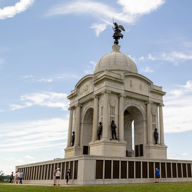 A large white, square stone memorial with domes top.