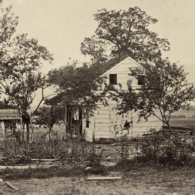 Historical photograph of a small farmhouse.