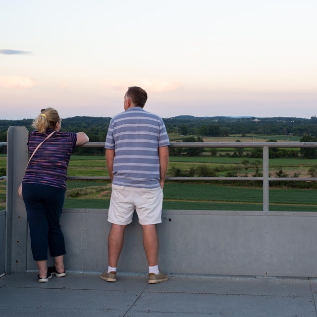Two visitors atop the Oak Ridge tower overlooking the battlefield.