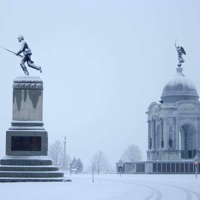 Two large monuments appear in snow with smaller monuments in the surrounding area.