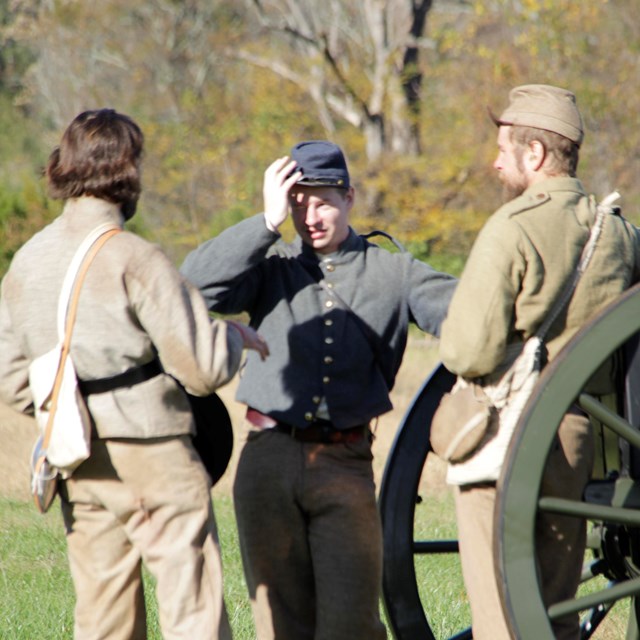 Confederate living history performers standing around a canon.