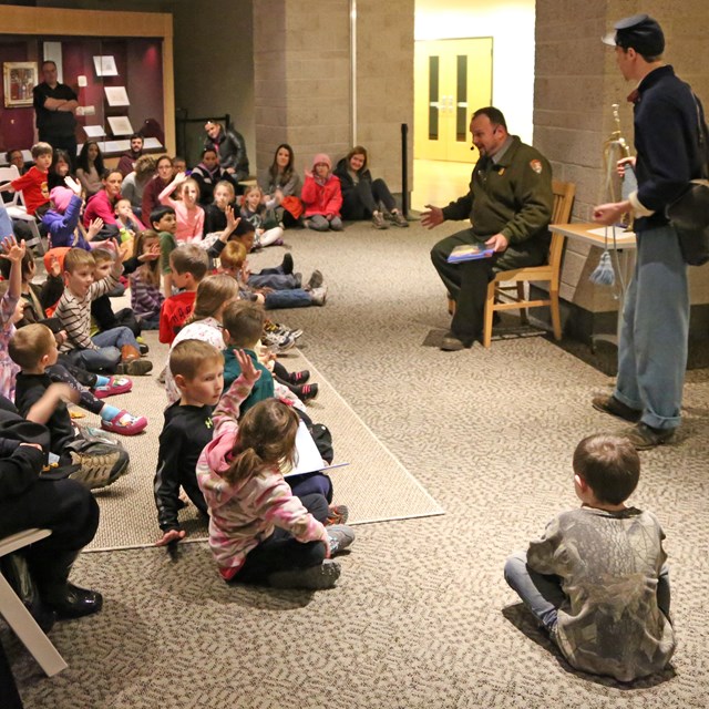 A Park Ranger Reads a Book to a Group of Young Children