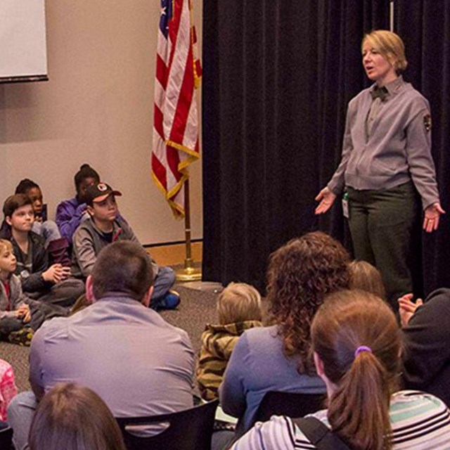 A Park Ranger presenting to school students and families.