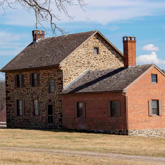 A photo of the Bushman House with Little Round Top in the background.