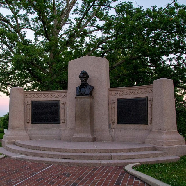 Granite monument with two bronze plaques and a bronze bust of Abraham Lincoln