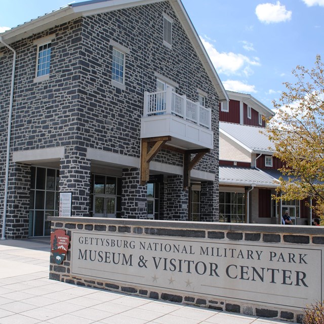 The park sign is visible in front of the corner of the Museum and Visitor Center.