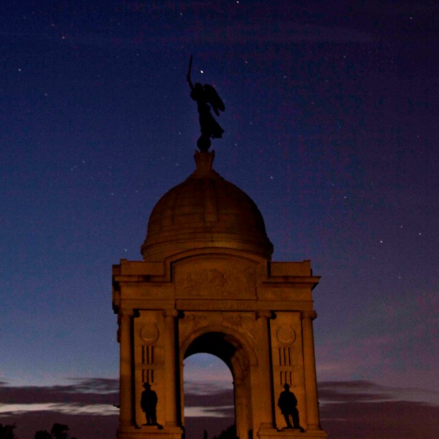 The Pennsylvania Memorial, a large domed memorial, as seen in early evening with a starry sky.