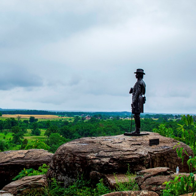 Statue on a rock above a field