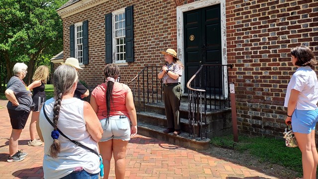 A ranger leading a group into the Memorial House Museum on a public tour.