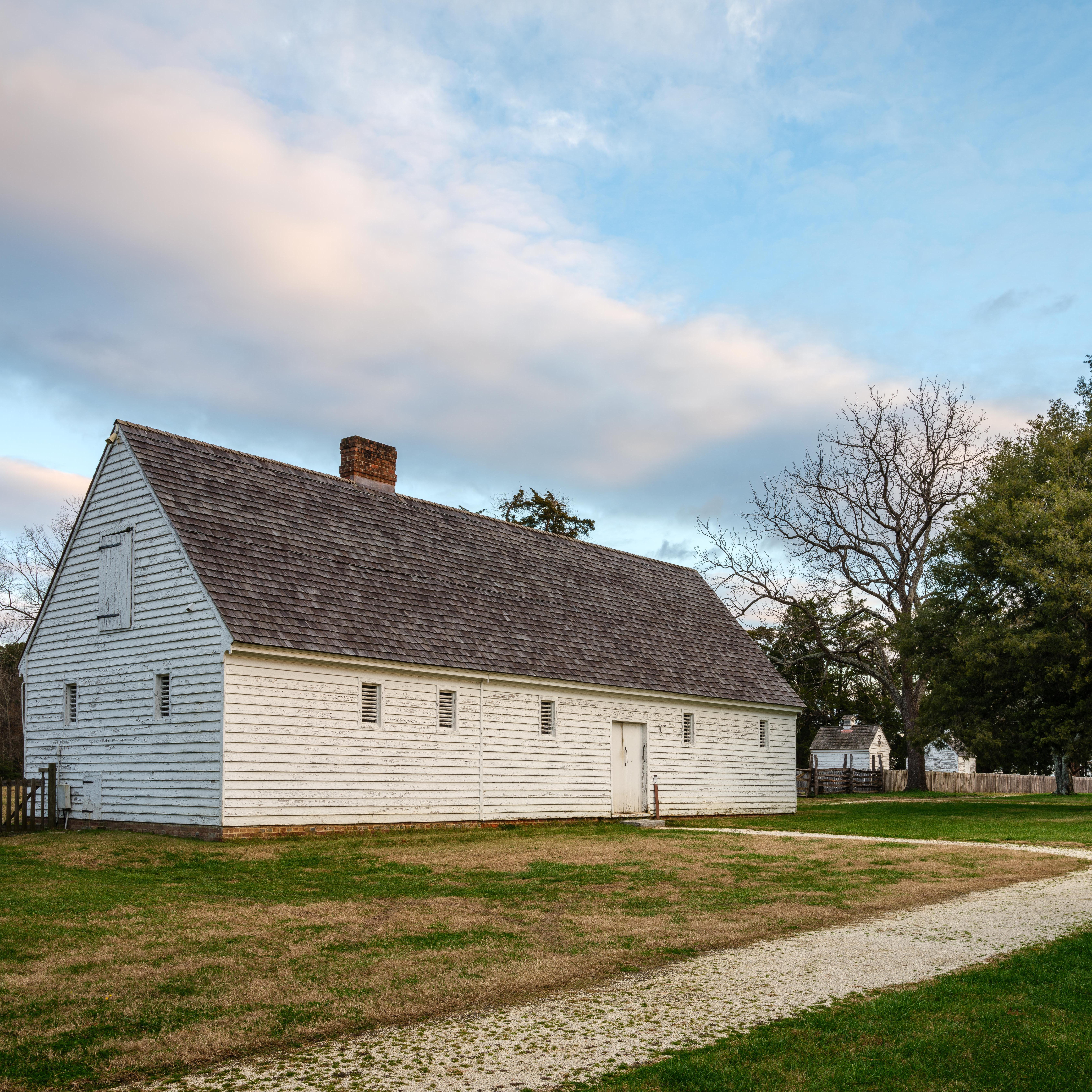 A white barn with a white gravel path leading to the entrance.