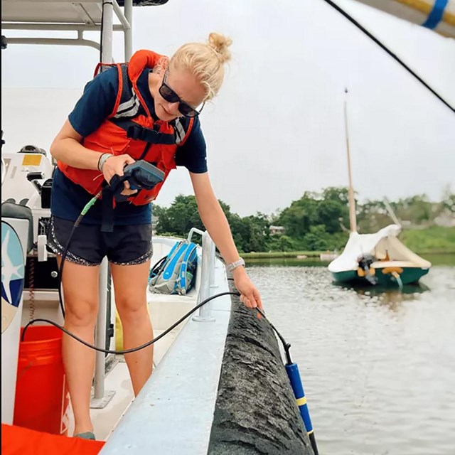 Michaela Compo testing the water in Pope's Creek.
