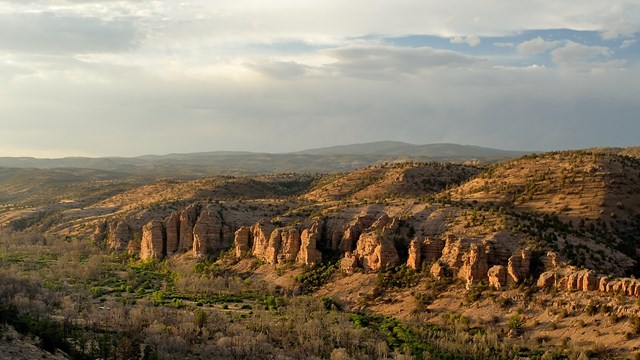 Sweeping view of Wilderness area canyon, mountains and hills at golden hour.