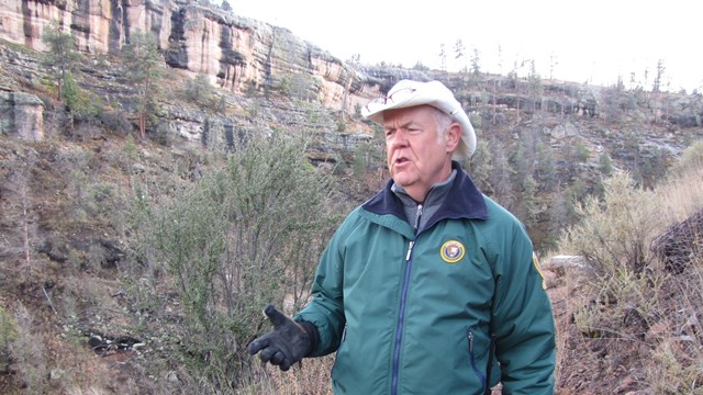 Volunteer on the park trail near the dwellings.