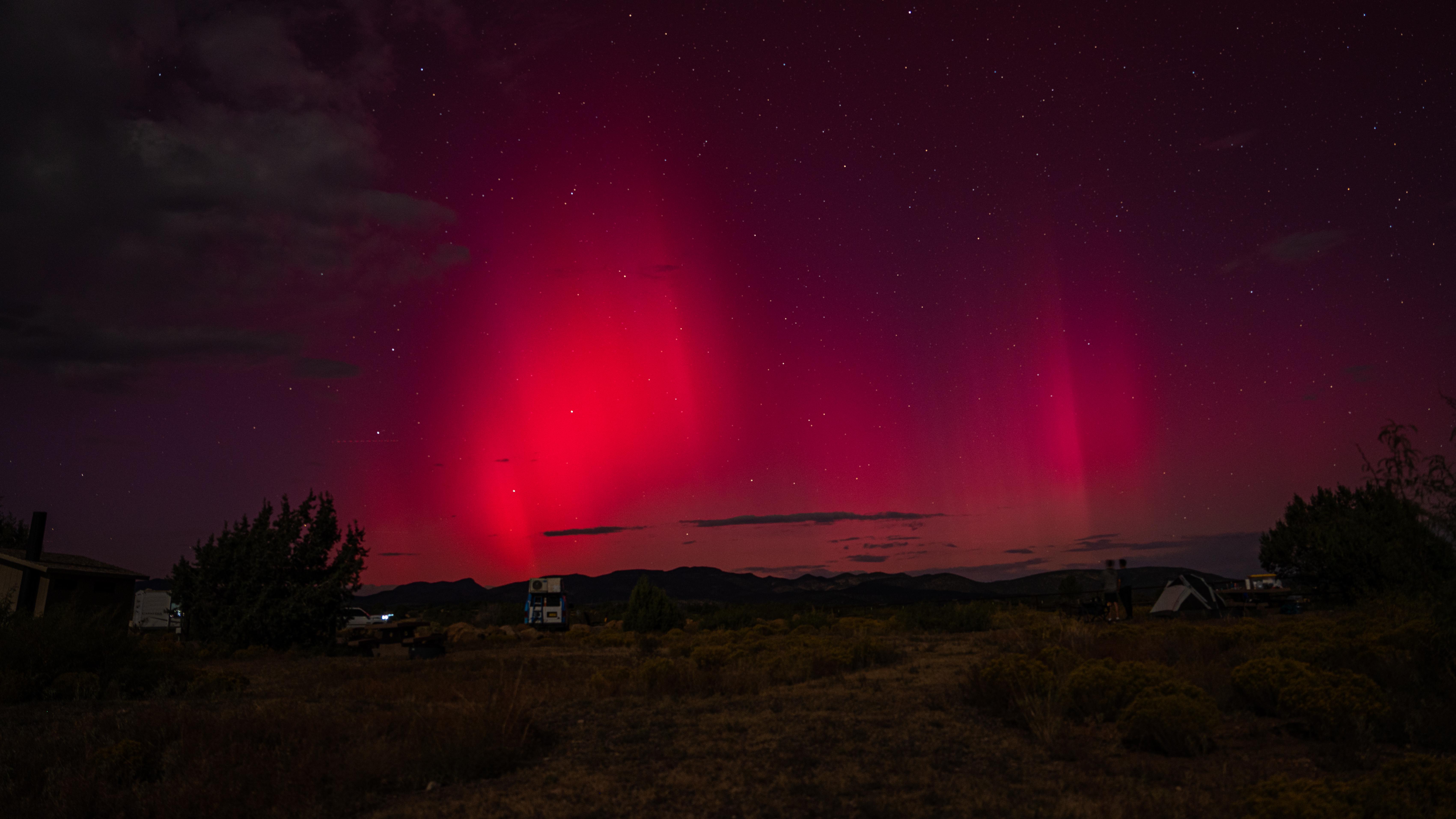 The sky is lit up with red, purple, and slight bit of green during an aurora event.