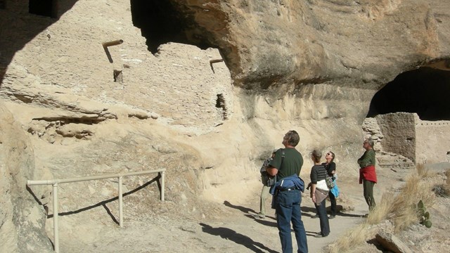 Visitors look up at an ancient structure at Gila Cliff Dwellings.