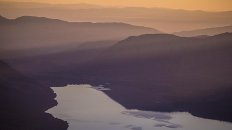Photo of a lake with yellow sunset light. 