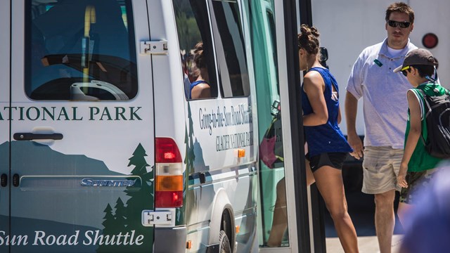 People load onto a shuttle bus. 