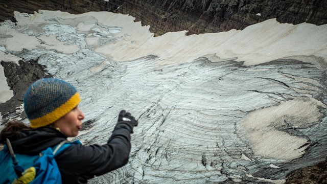 A person points at a glacier.