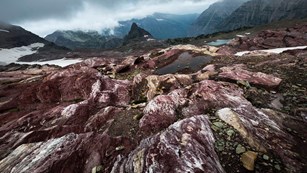 barren rock in glacier basin under dark clouds