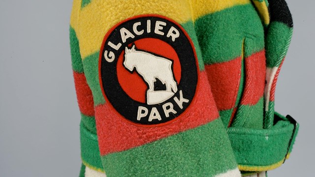 Sleeve of brightly colored, striped coat adorned with "Glacier Park" seal