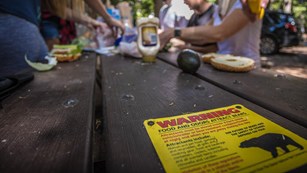 A bear warning on a table where people are eating. 