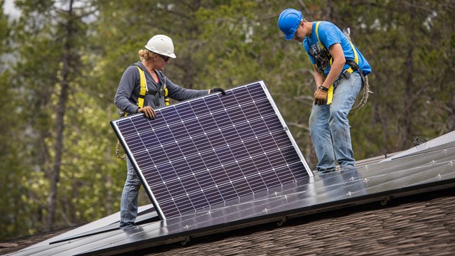 Workers install solar panels. 