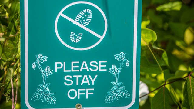 a sign about staying on the trail