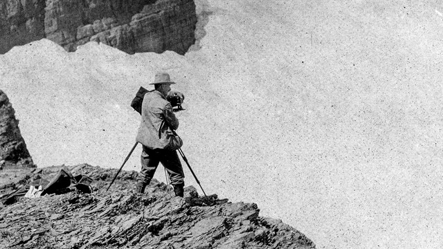 Historic image of a person photographing a glacier