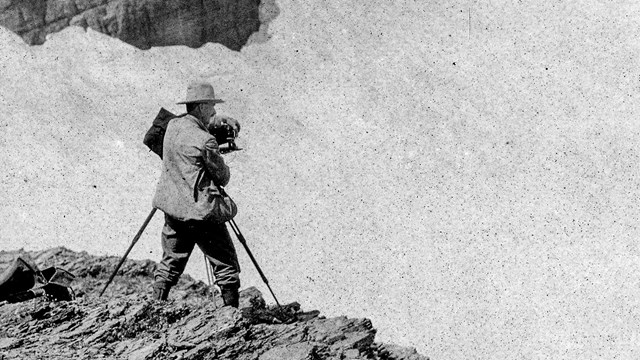 Historic image of a person photographing a glacier