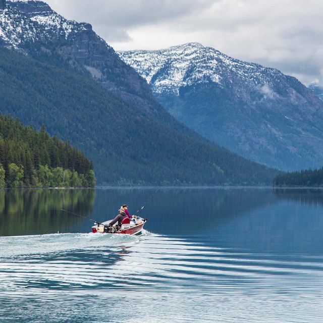 Visitors boating on Bowman Lake on an overcast day