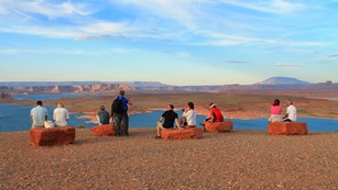 people sitting on large flat boulders looking out over the landscape