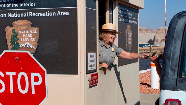 Park Ranger in fee booth reaches out to car