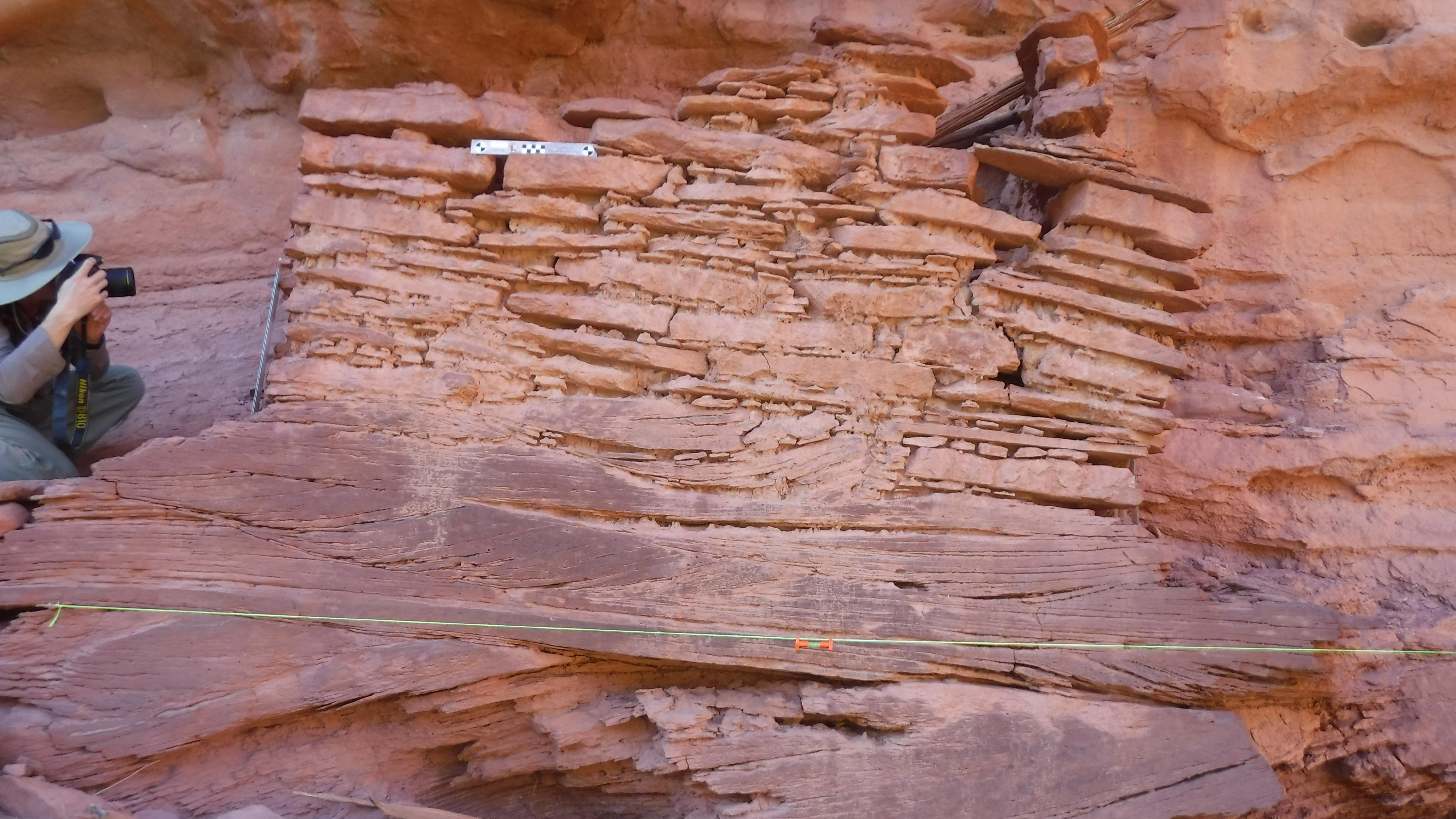 park ranger with scientific measuring tools at an ancient stone masonry structre
