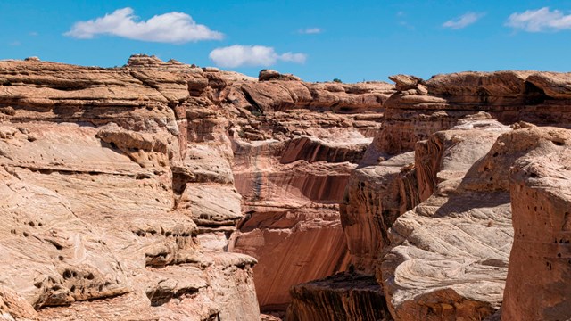 curving light colored sandstone canyon under clear skies