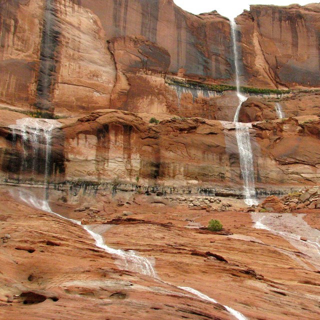Waterfalls cascade down sandstone rockface