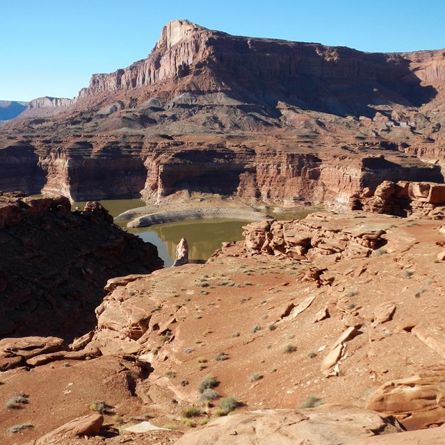 View of rocky terrain and mesas with peak at green waters