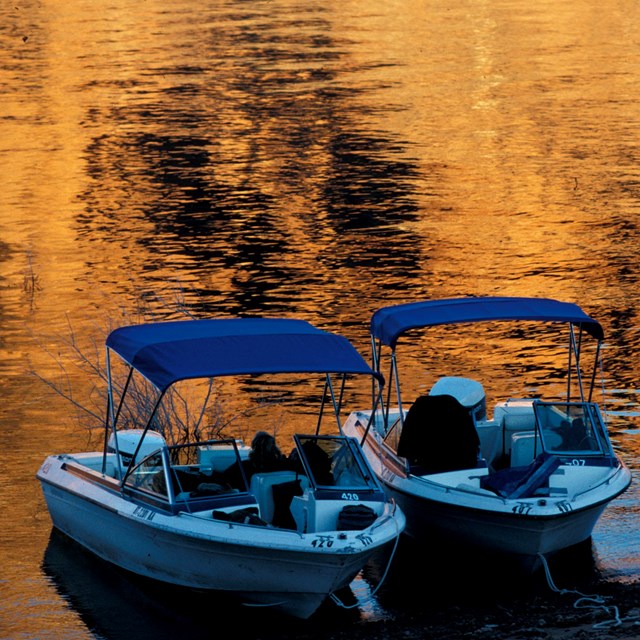 Three small boats beached during sunset