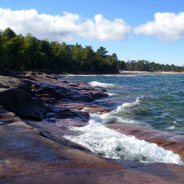 Sandstone shoreline, the blue lake, and a curving beach