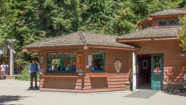 wood building with muir woods staff standing in front