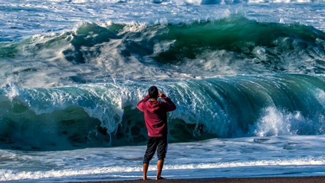 man faces crashing waves