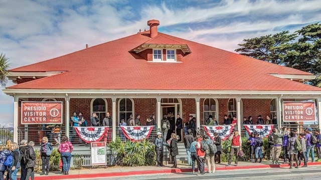 people gathered outside brick Presidio Visitor Center