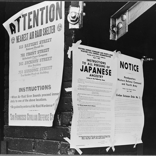 historical photo of Exclusion posters taped to street pole
