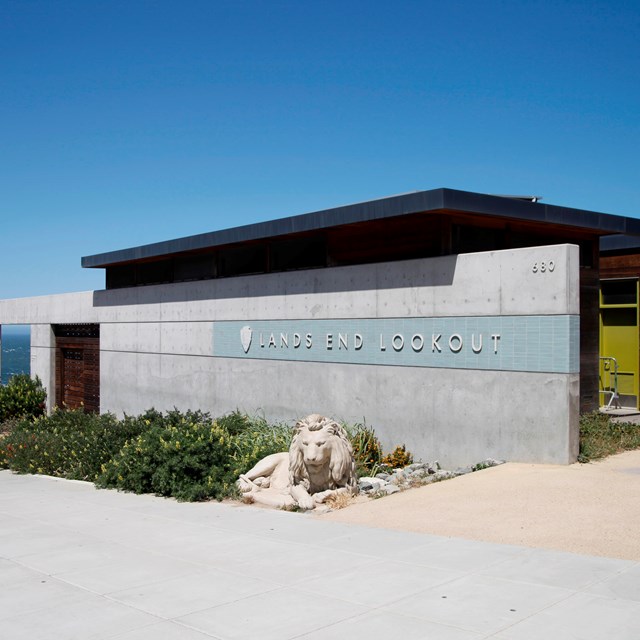 lion sculpture in front of slate and wood building