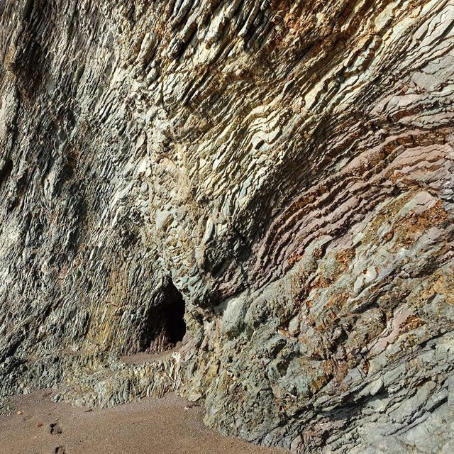 Close up image of layers of rock on a beachside cave.