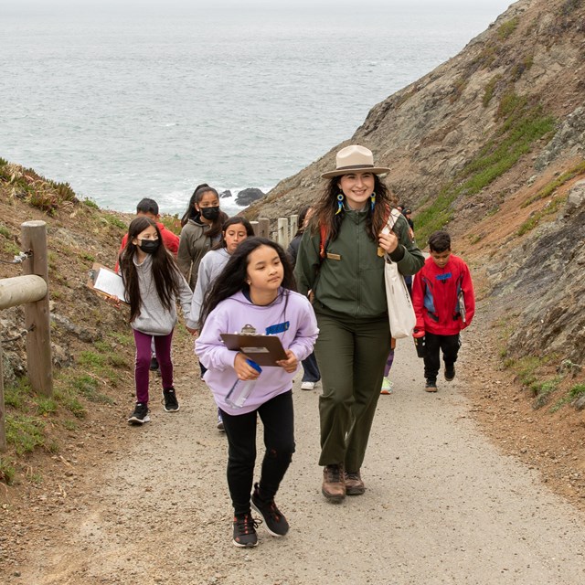 Ranger leads a group of students up a hilly path in the Marin Headlands